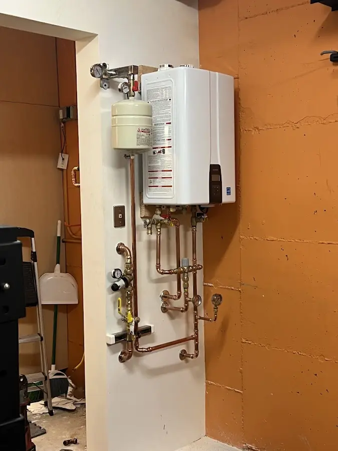 Plumbing technician inspecting water heater connections in Elkridge